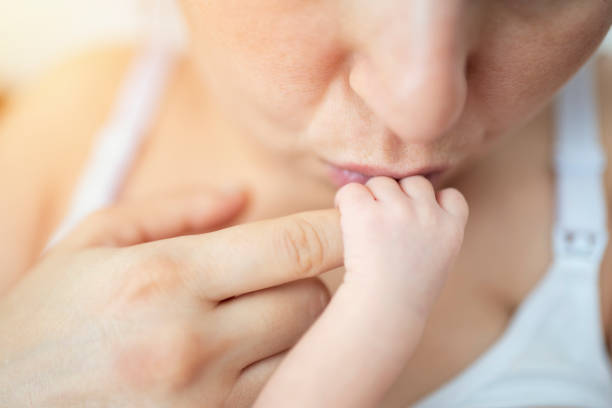 Mother breastfeeding newborn baby, first breastfeeding