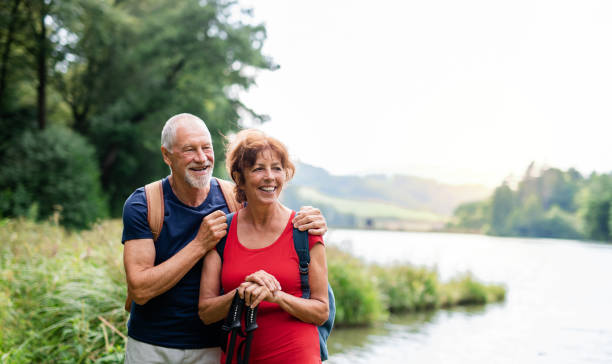 istock Senior tourist couple on a walk in nature, standing by lake. 1188856441