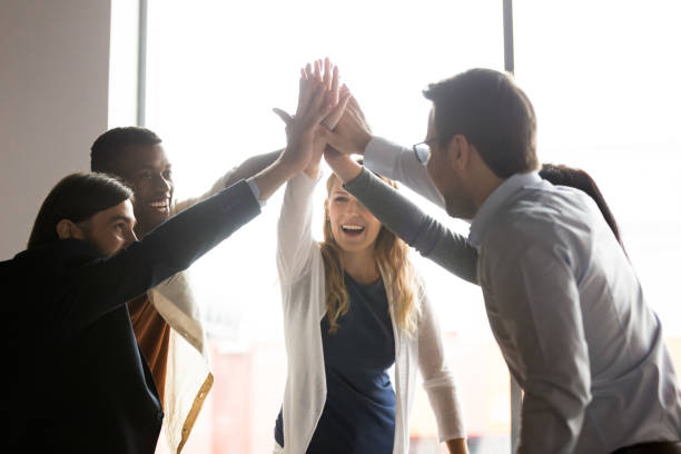 istock Overjoyed mixed race group of employees giving high five. 1188856984