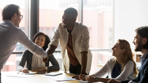 istock Confident team leader shaking hands with smiling african american employee. 1188856996