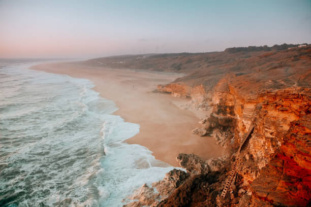 Rocky cliffs and the ocean Sunset in Nazare nazare surf stock pictures, royalty-free photos & images