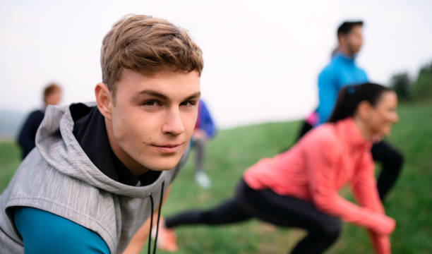istock Large group of fit and active people stretching after doing exercise in nature. 1188860240