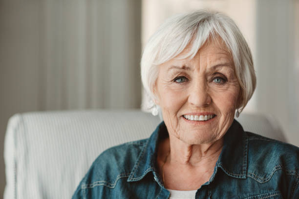 mulher sênior de sorriso que relaxa em casa na tarde - só mulheres idosas - fotografias e filmes do acervo