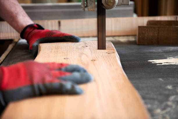 istock Carpenter cutting a wood plank with a band saw 1188863061