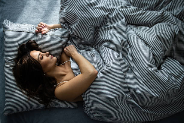 Pretty, young woman sleeping in her bed stock photo