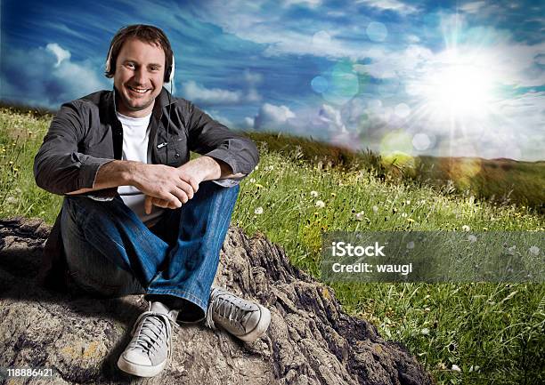 Junger Mann Sitzt In Der Natur Hören Musik Stockfoto und mehr Bilder von Ein Mann allein - Ein Mann allein, Eine Person, Erwachsene Person