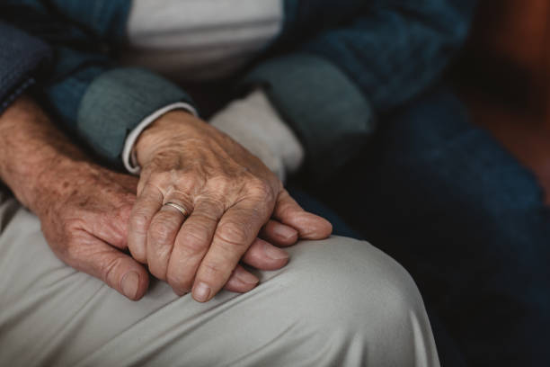 istock Senior couple holding hands while sitting together at home 1188865462