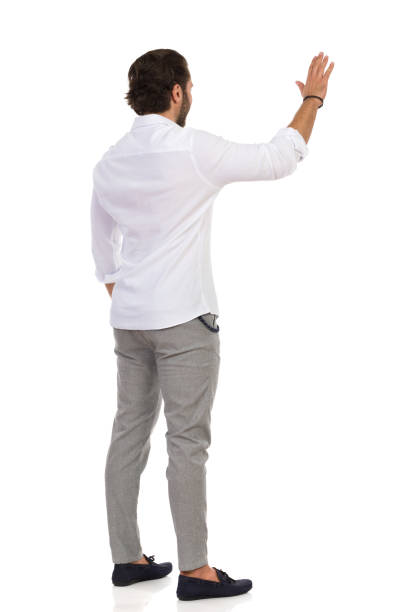 istock Handsome Man Is Waving Hand And Looking Away. Rear View. 1188866114