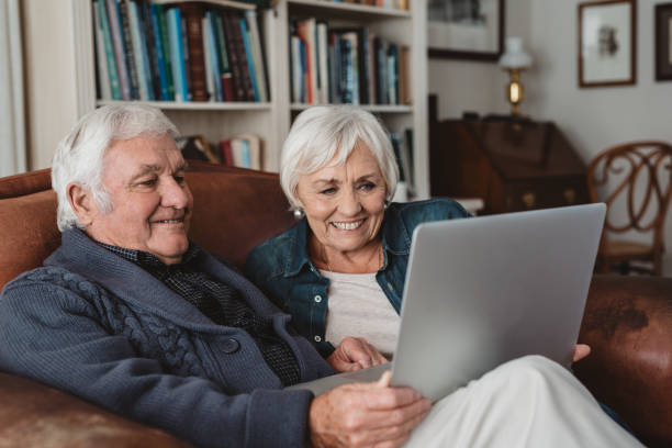 istock Smiling senior couple sitting on their sofa using a laptop 1188866159