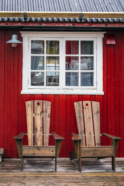 Window and chairs infront of traditional red wooden houses, rorbuer in the small fishing village of Nusfjord, Lofoten islands, Norway.