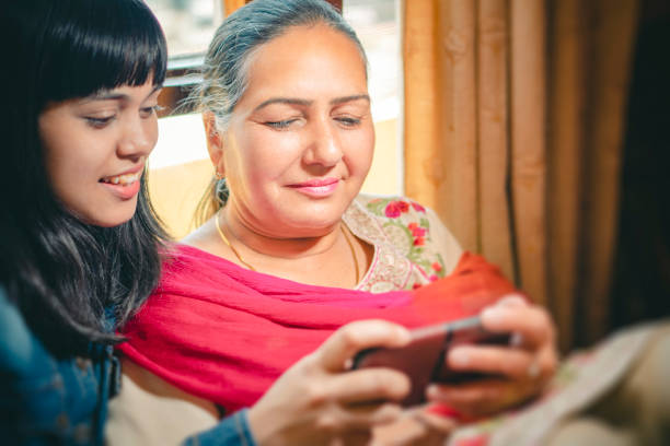 istock Happy mother and daughter share a smartphone. 1188868946