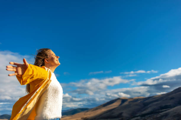 mulher que toma uma respiração na frente de uma vista espectacular - braços no ar - fotografias e filmes do acervo