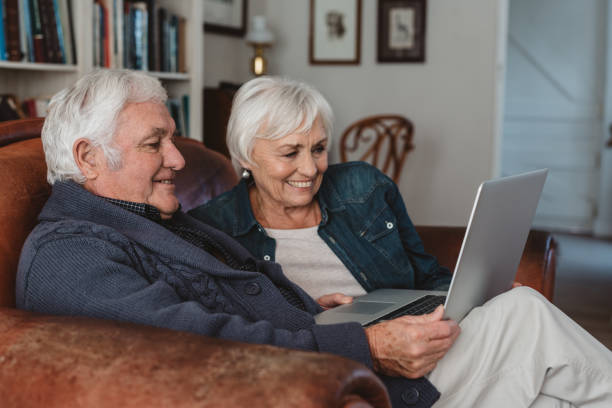 istock Smiling senior couple using a laptop together on their sofa 1188870400