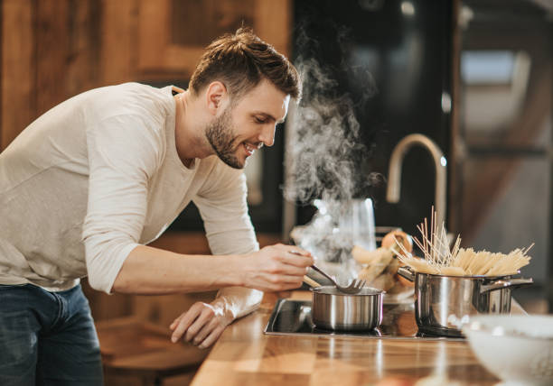 istock Young happy bachelor enjoying while cooking in the kitchen. 1188870432