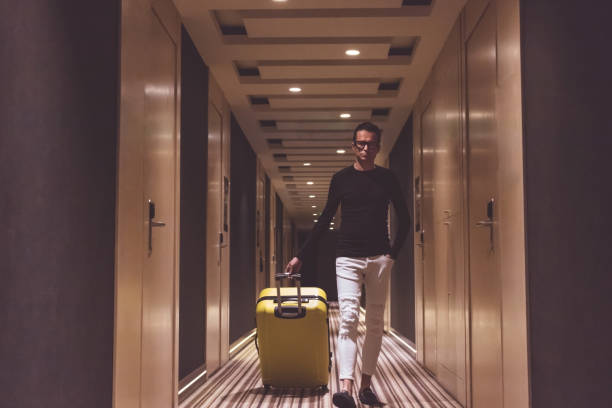 istock Man with suitcase walking in hotel lobby. 1188872162