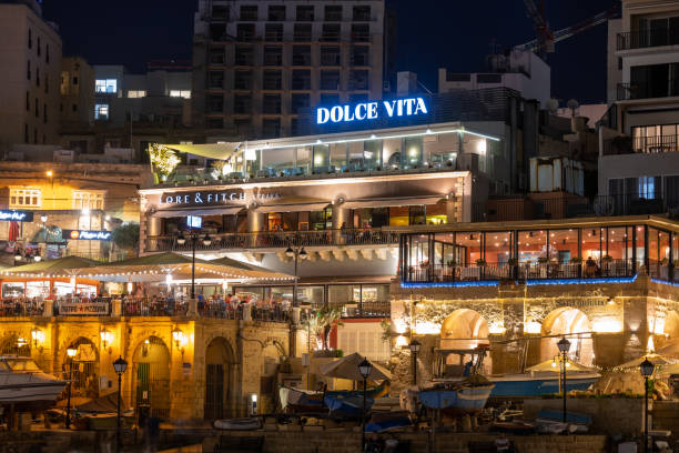 Restaurants in St Julian Town in Malta at Night Paceville, St Julian, Malta - October 10, 2019: Restaurants Dolce Vita, Lore and Fitch and San Giuliano in Paceville, Saint Julian town at night st julians bay stock pictures, royalty-free photos & images