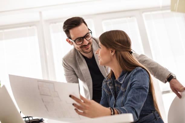 istock Colleagues in architect company reviewing technical drawings 1188873028