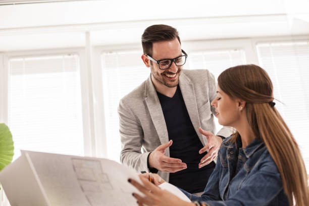 istock Young business people reviewing architectural technical drawings 1188873035