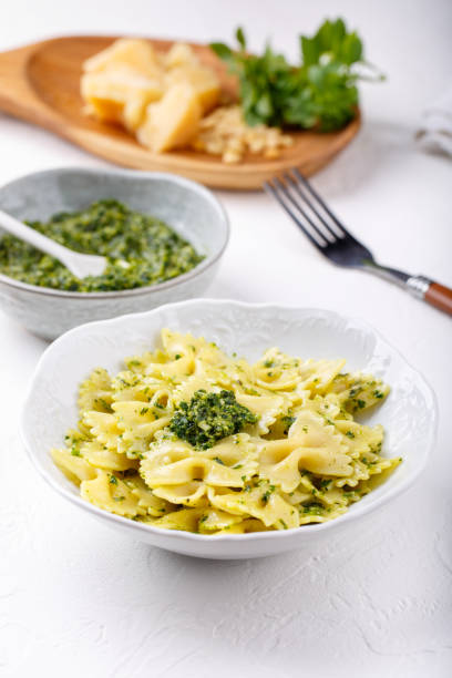 istock Farfalle pasta in  basil pesto sauce in white plate on white table. 1188873442