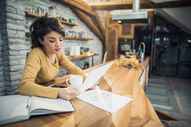 istock Female freelance worker working on documents at home. 1188873695