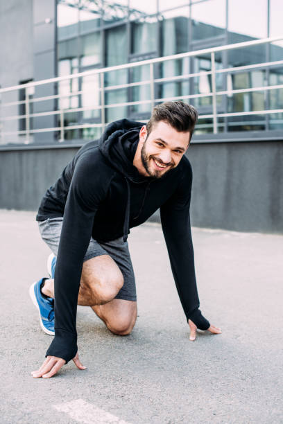 istock smiling handsome sportsman in starting position ready to run 1188874535