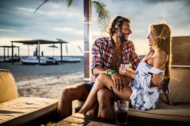 istock Cheerful couple talking while enjoying in beach bar. 1188877356
