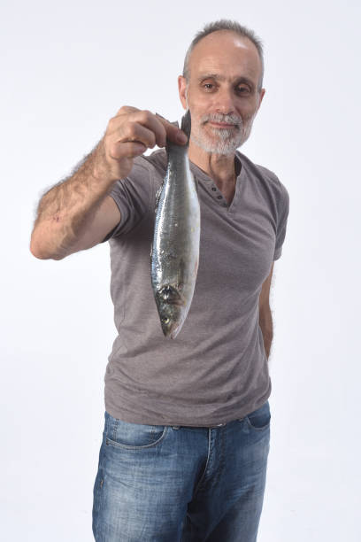 istock man with sea bass on white background 1188879686