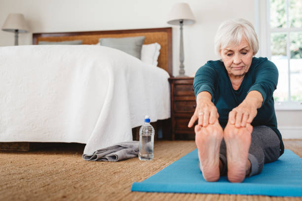 istock Active senior woman touching her toes while doing yoga 1188881310