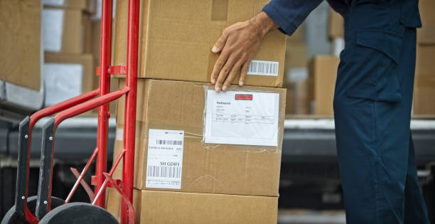 istock Delivery man stacking packages on cart 1188881807