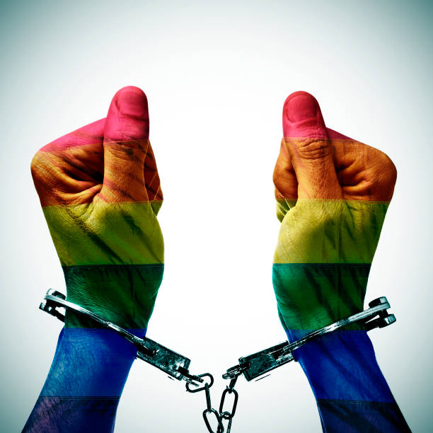 handcuffed hands denouncing the criminalization of homosexuality - gay pride flag gay pride gay man homosexual imagens e fotografias de stock