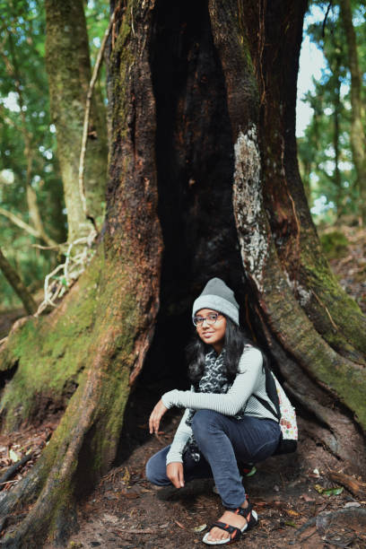 istock Tweenage girl sitting next to tree hole 1188882721