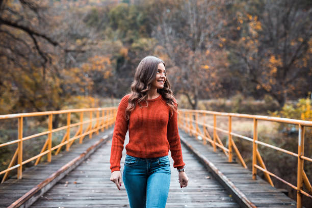 istock Beauty in orange sweater walking on the bridge 1188883465