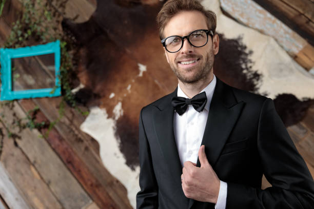 Hopeful fashion model adjusting his jacket and smiling