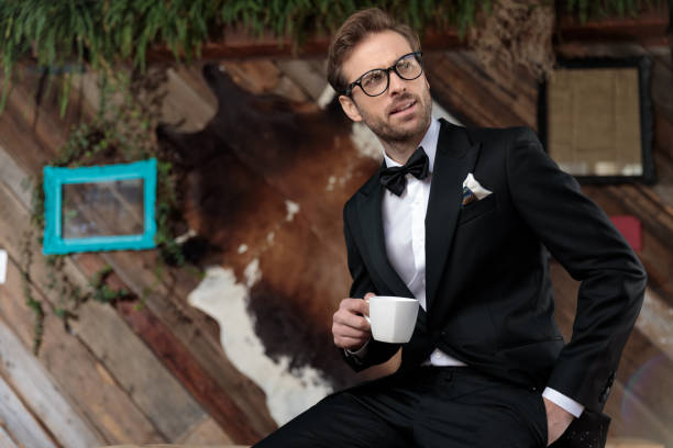 Thoughtful groom holding a coffee cup and looking away
