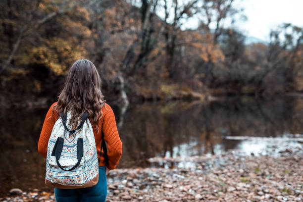 istock Woman looking autumn colored river and trees 1188886733