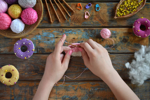 istock Making crochet amigurumi donuts. Toy for babies or trinket.  On the table threads, needles, hook, cotton yarn. Handmade gift. Income from hobby. DIY crafts concept. Step 1 - knit all details. 1188887554