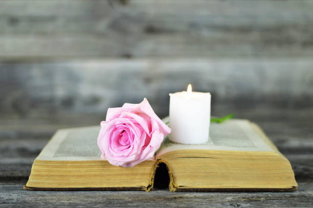 istock Sympathy card with burning candle and rose on open book 1188894150