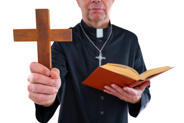 Priest bald with cassock exorcism cross and bible isolated on white