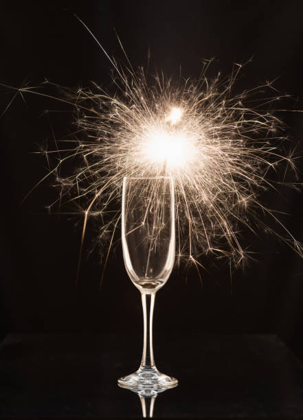 istock Champagne glass with lit sparkler against a dark background 1188897569