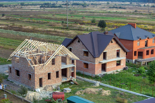 istock Unfinished brick house with wooden roof structure under construction. 1188899436