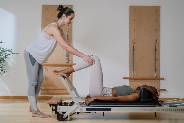 sportswoman doing pilates exercise with her trainer - secrecy instructor exercising individuality imagens e fotografias de stock