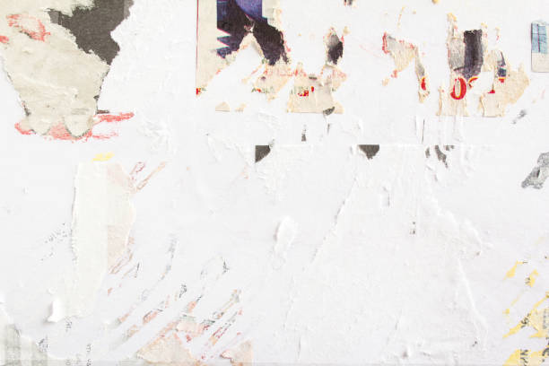 istock Old torn paper ads on billboard with traces of glue. 1188900813