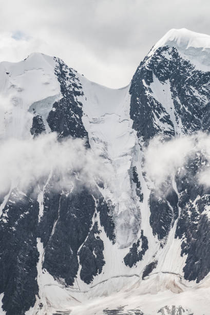 istock Snowy mountain peak in low clouds. 1188901238