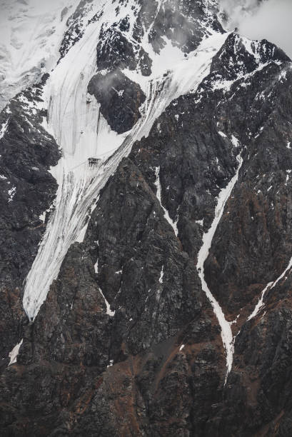 istock Massive hanging glacier on big mountain in low clouds. 1188901254