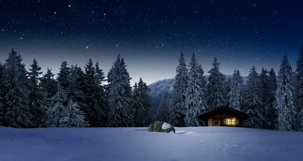 istock Illuminated log cabin in winter night 1188901470