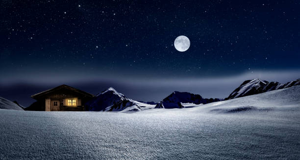 istock Illuminated log cabin in winter night 1188901531