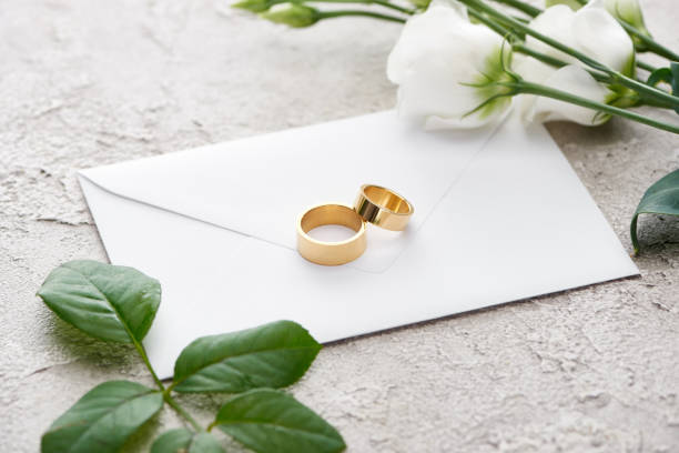 istock golden rings on white envelope near eustoma flowers on grey textured 1188903370