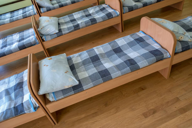 istock Many small beds in daycare preeschool empty bedroom. 1188903707