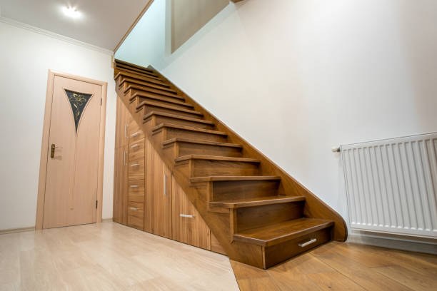 istock Modern architecture interior with luxury hallway with glossy wooden stairs in multi-storey house. Custom built pullout cabinets on glides in slots under stairs. Use of space for storage. 1188903752