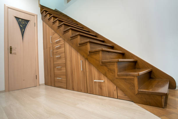 istock Modern architecture interior with luxury hallway with glossy wooden stairs in multi-storey house. Custom built pullout cabinets on glides in slots under stairs. Use of space for storage. 1188903754
